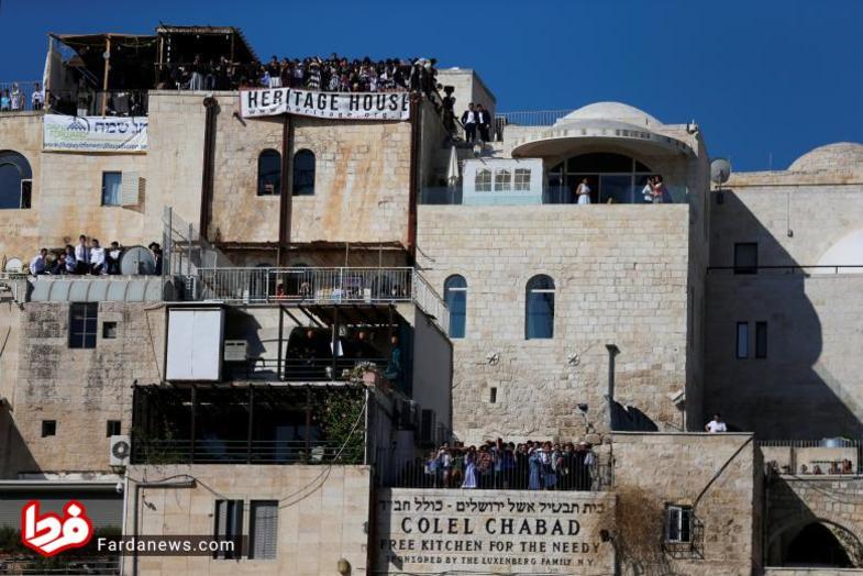 تماشاگرانی که از روی بالکن یا پشت بام خانه ها در حال نگاه کردن به عبادت کننده گان یهودی حاضر در جشن