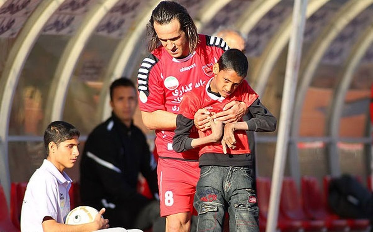 پسرمعلول در آغوش علی‌کریمی/عکس