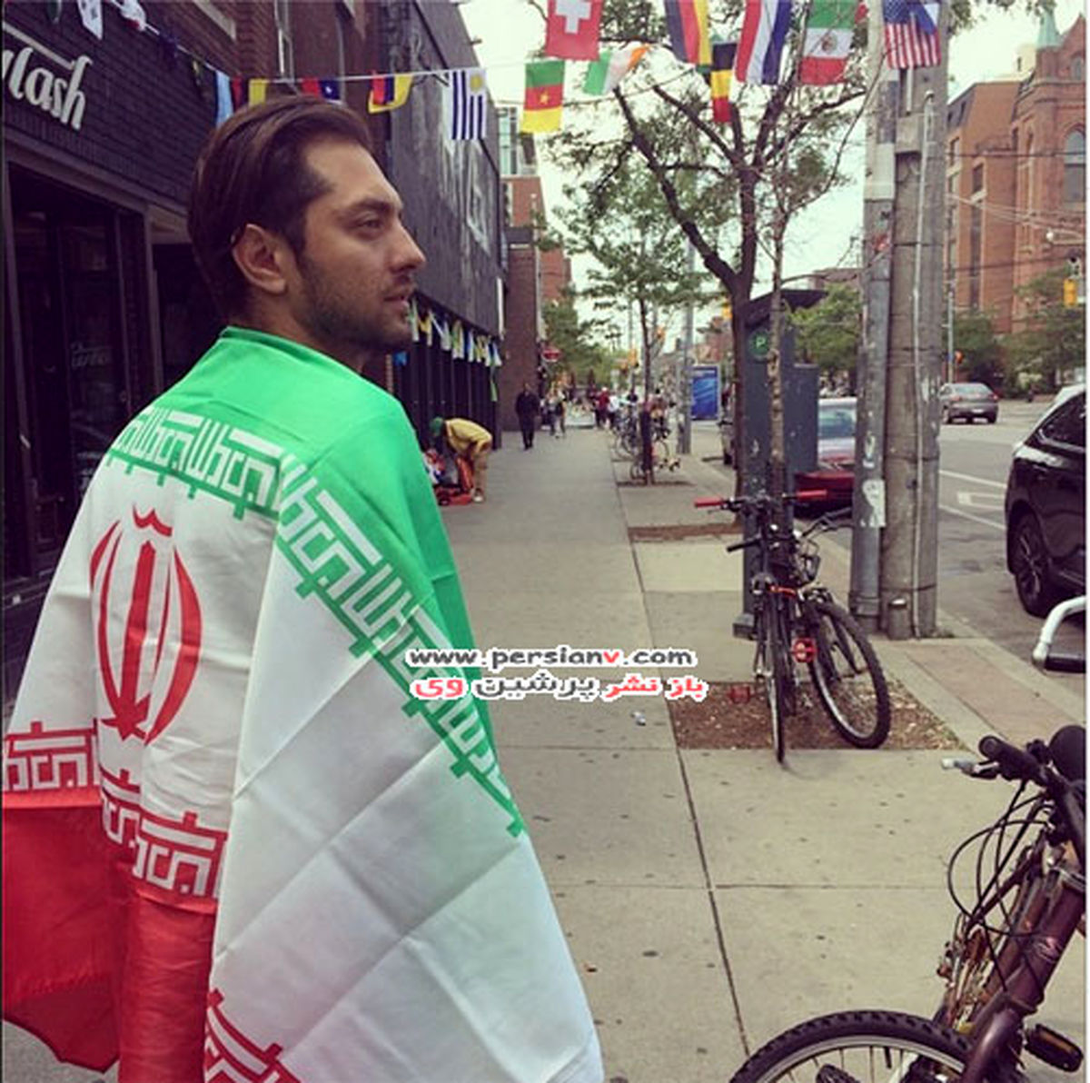 بهرام رادان در خارج با پرچم ایران/عکس